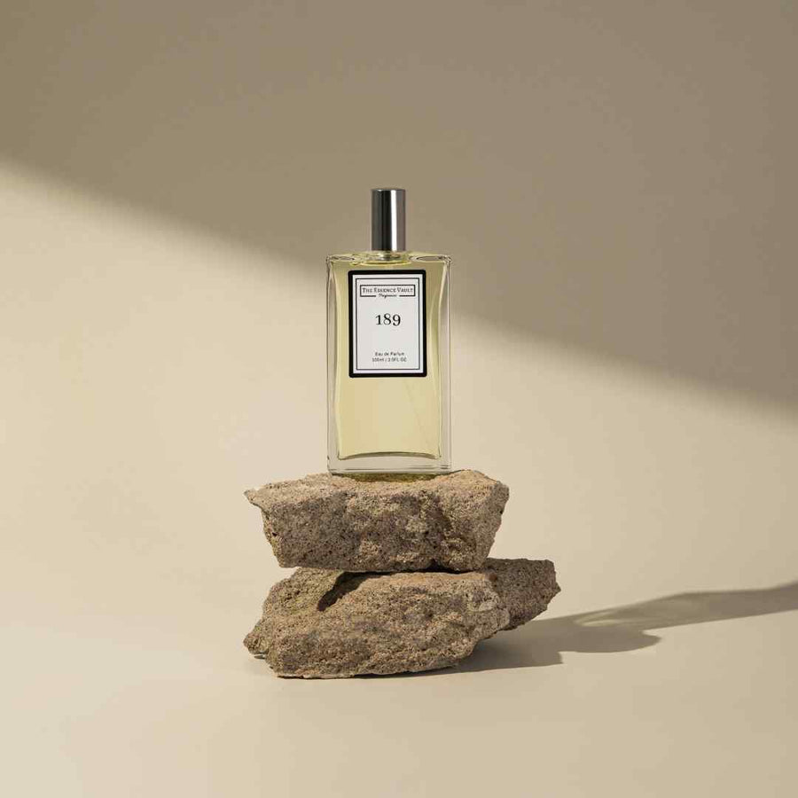 Image of a perfume from The Essence Vault on placed on some rocks for aesthetic, for the blog The Best Fragrances for Summer (Our Top 10)