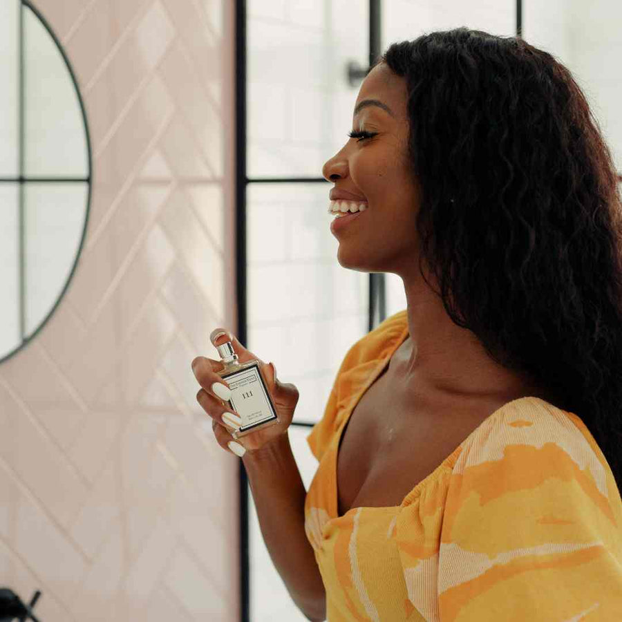 Image of a woman holding a perfume from The Essence Vault for the blog, Be Boujee on a Budget: Affordable Perfume for Women