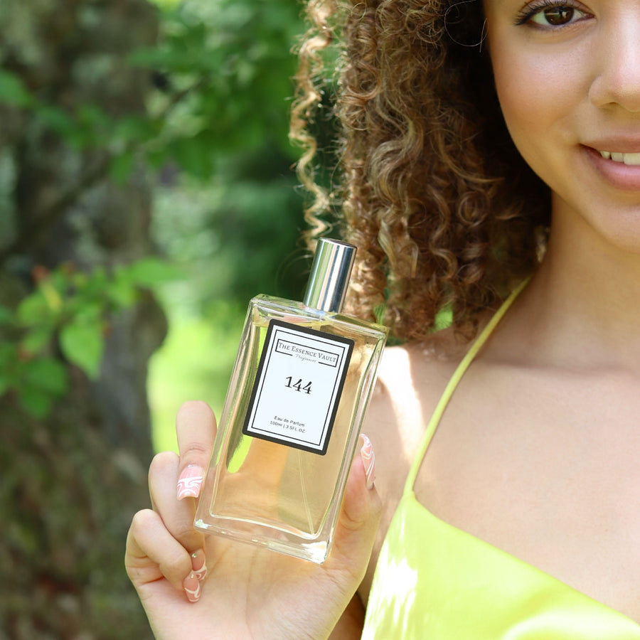 Image of a woman holding a perfume from The Essence Vault, is perfume a good gift for Valentine's Day?